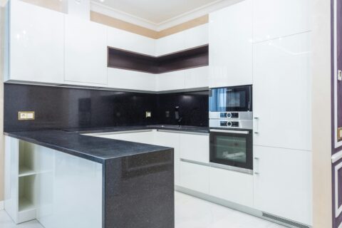 Modern kitchen designed with DIY Kitchens Planner showing white cabinets and black granite countertops.