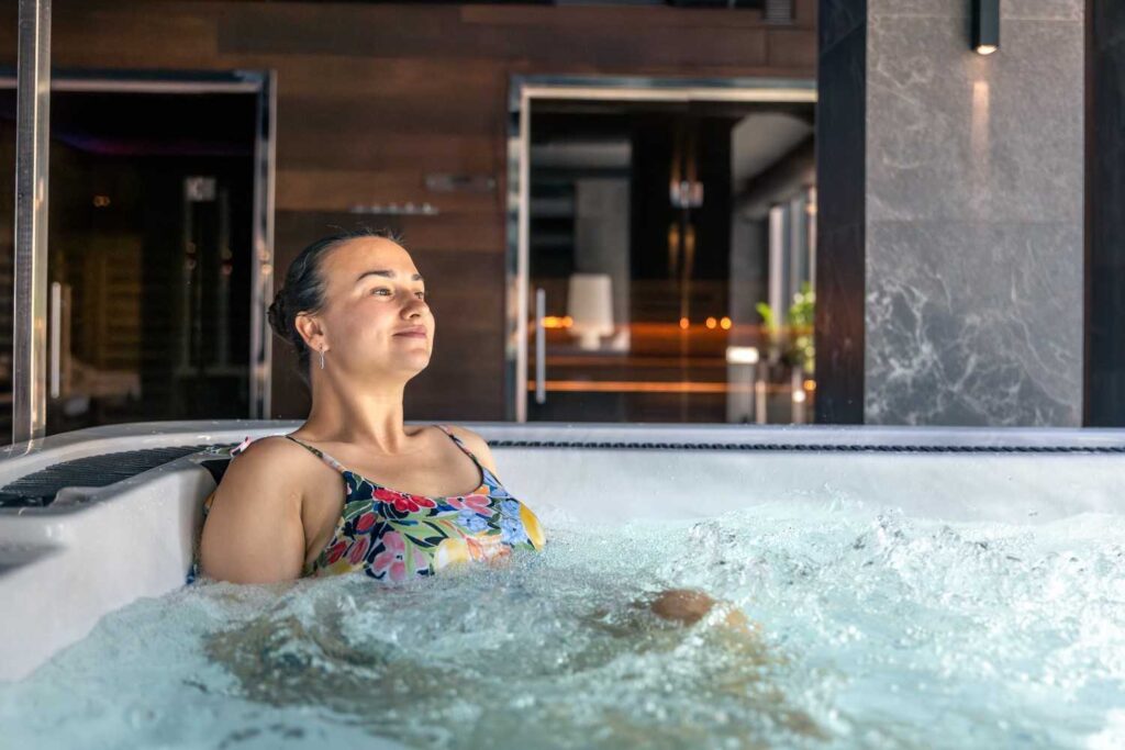 Woman relaxing in a private room hot tub hotels, enjoying a peaceful spa-style stay with modern interior design