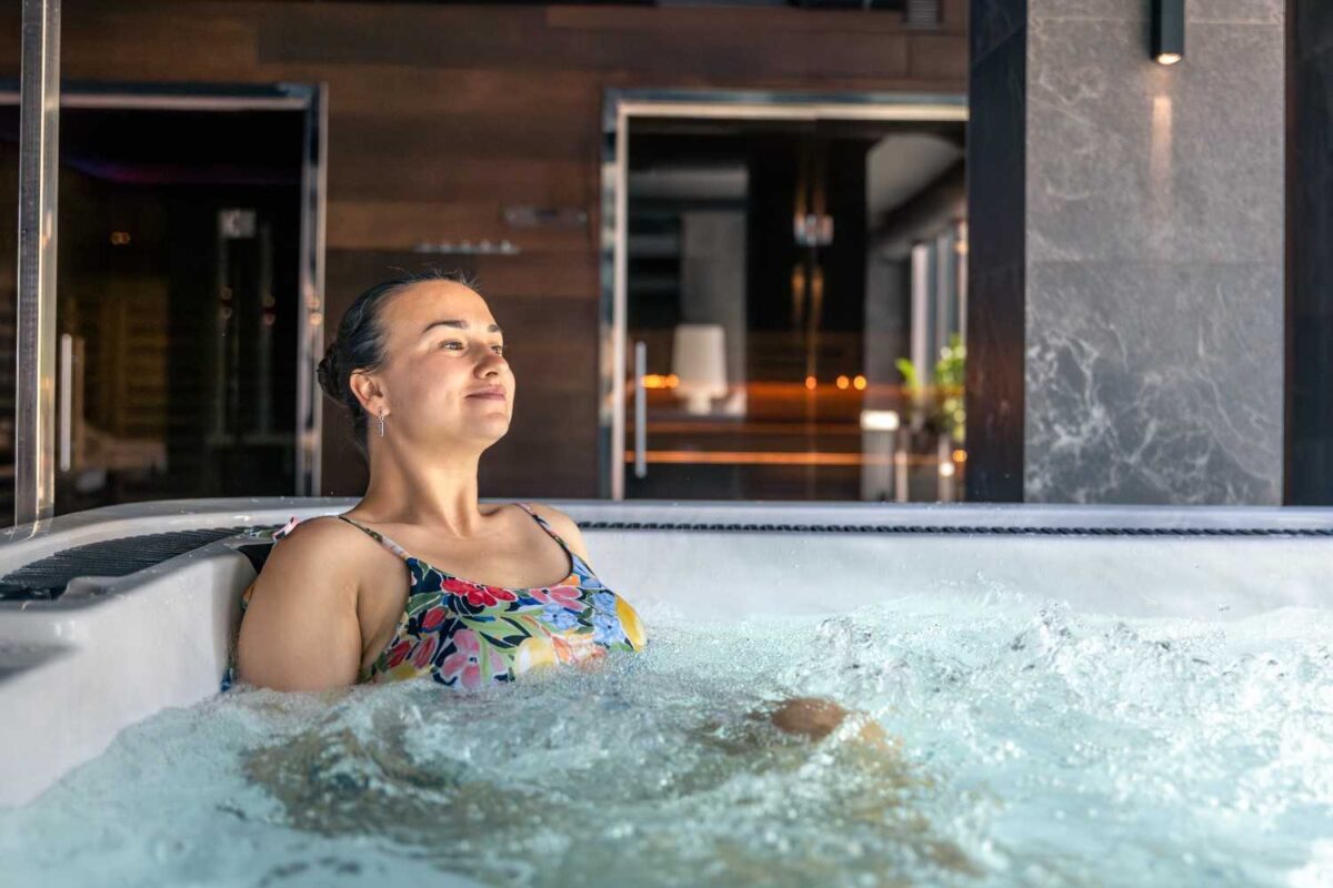 Woman relaxing in a private room hot tub hotels, enjoying a peaceful spa-style stay with modern interior design