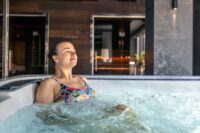 Woman relaxing in a private room hot tub hotels, enjoying a peaceful spa-style stay with modern interior design